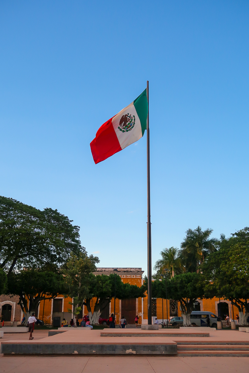 Mexican flag standing tall in a plaza in Izamal, Mexico. In this guide, you'll find the best things to do in Izamal.