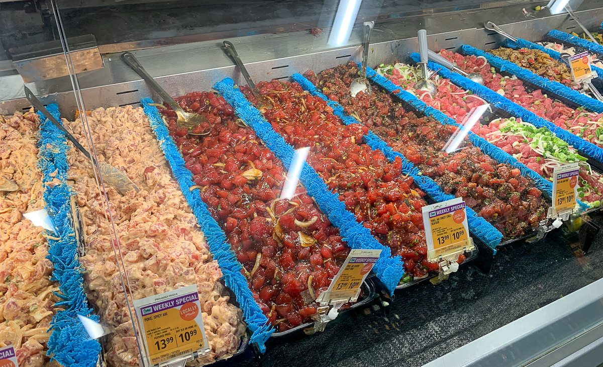 Choices of poke at the counter at Foodland. Your travel to Oahu, Hawaii won't be complete without trying poke bowls from Foodland.