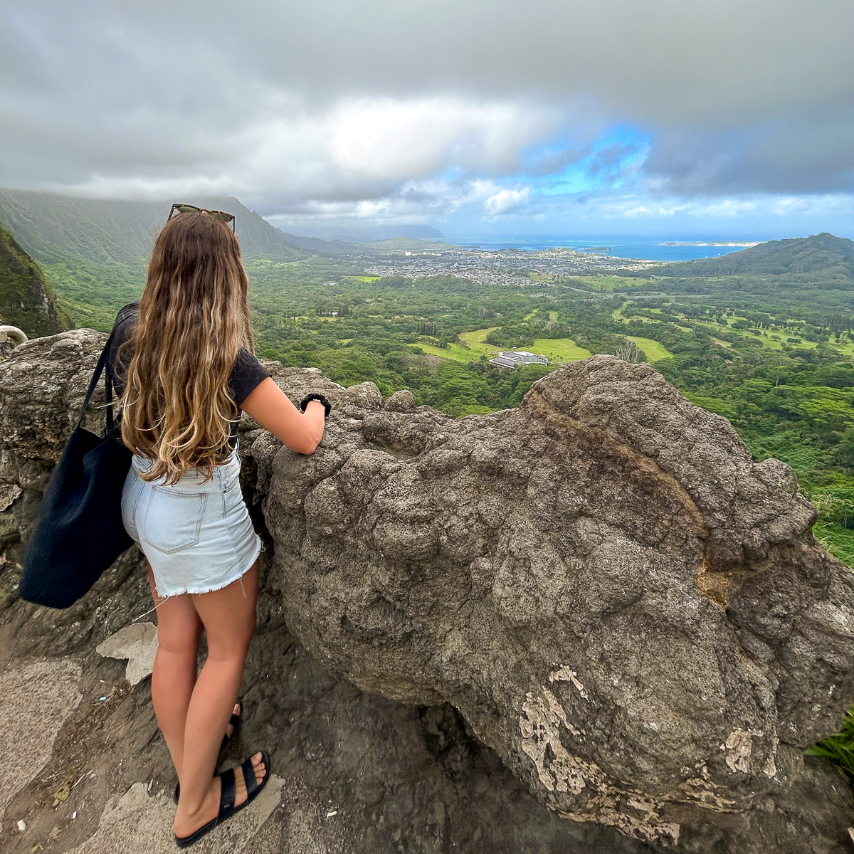 Maddy enjoying the panoramic views of mountains, Kailua town, and blue ocean from the Pali Highway lookout