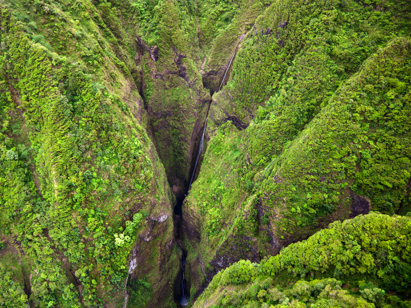 View of the Sacred Falls from a helicopter. Your Oahu itinerary won't be complete without a doors-off helicopter tour.