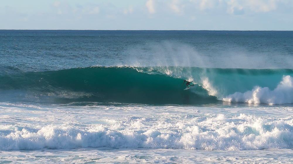 Surfer riding a big wave in a North Shore beach