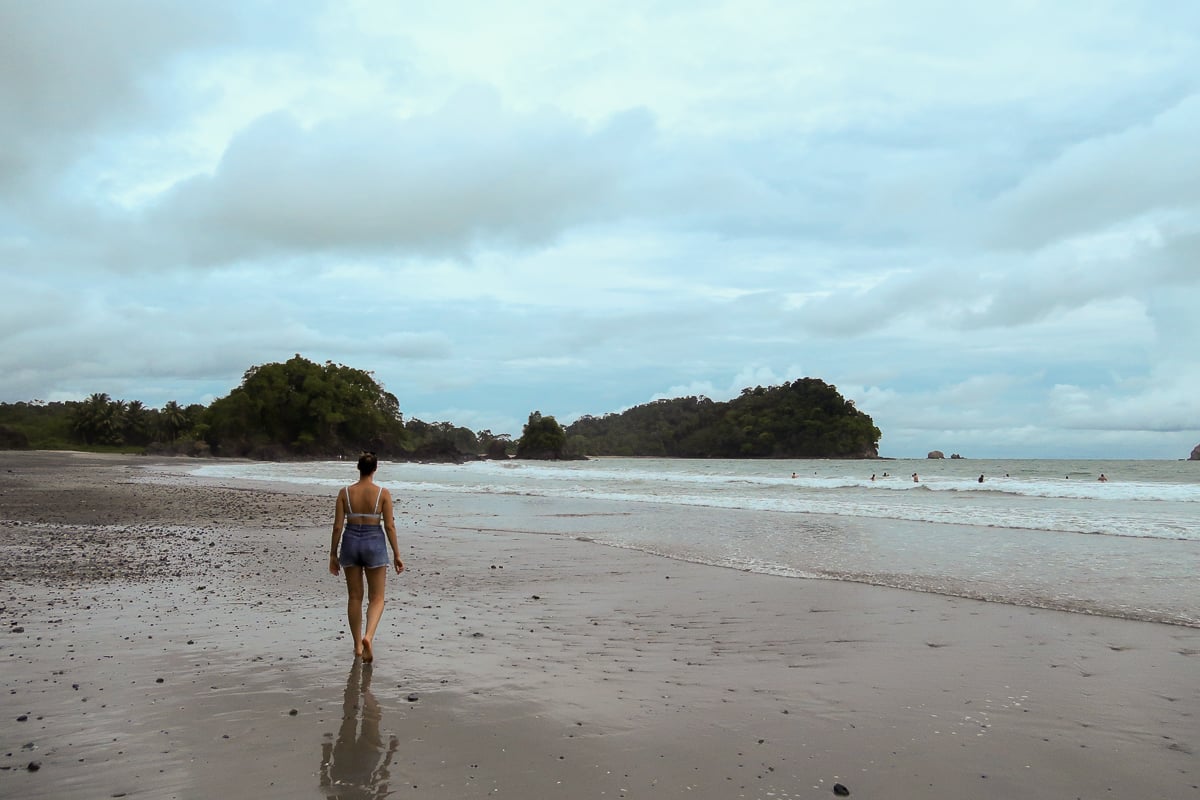 Maddy walking along Playa Espadilla. Taking a sunset stroll on the beach is one of the best things to do in Manuel Antonio, Costa Rica.