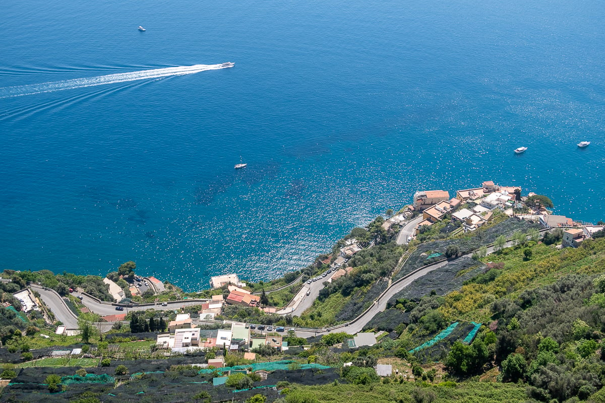 Boats cruising around the azure waters of Amalfi Coast as seen from Ravello's mountaintop town