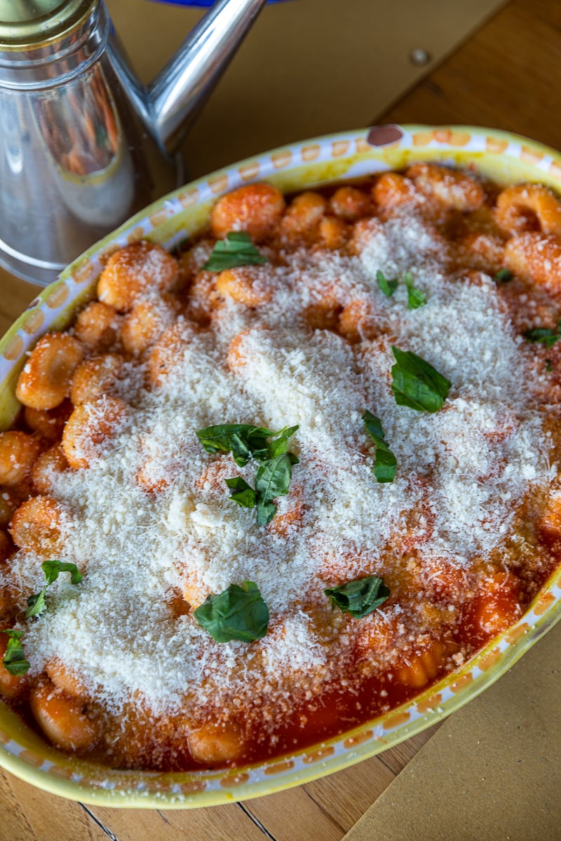 A plate of fresh gnocchi covered in tomato sauce and cheese