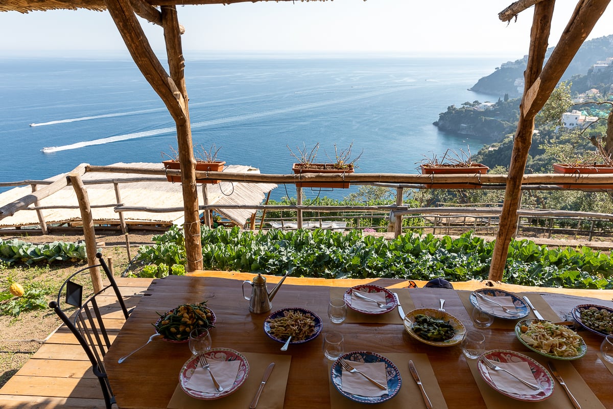 A table filled with food with an ocean view in the background - this is from a cooking class that I highly recommend including in your Amalfi Coast itinerary