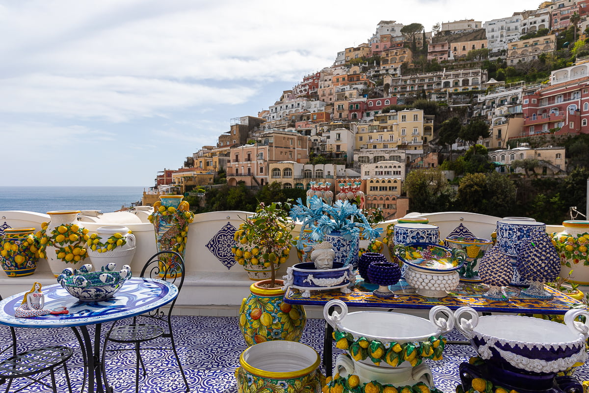 A beautiful collection of ceramics for sale in Positano with the town in the background