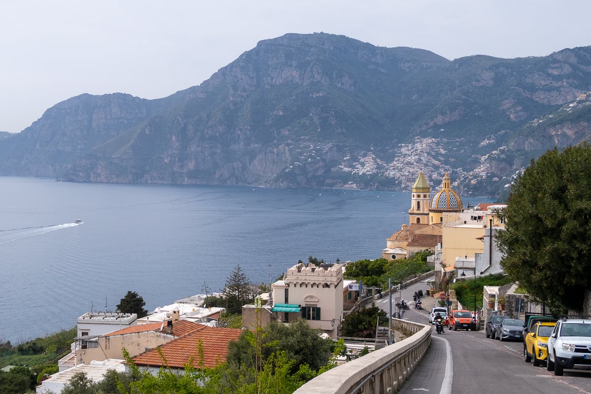 The street leading into the town of Praiano with the church dome in focus and mountains in the background