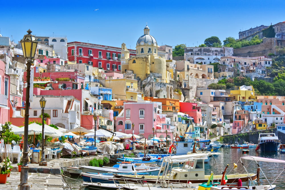 Colorful buildings and boats at Procida. Visiting this lesser-known island is one of the best things to do in Ischia, Italy.