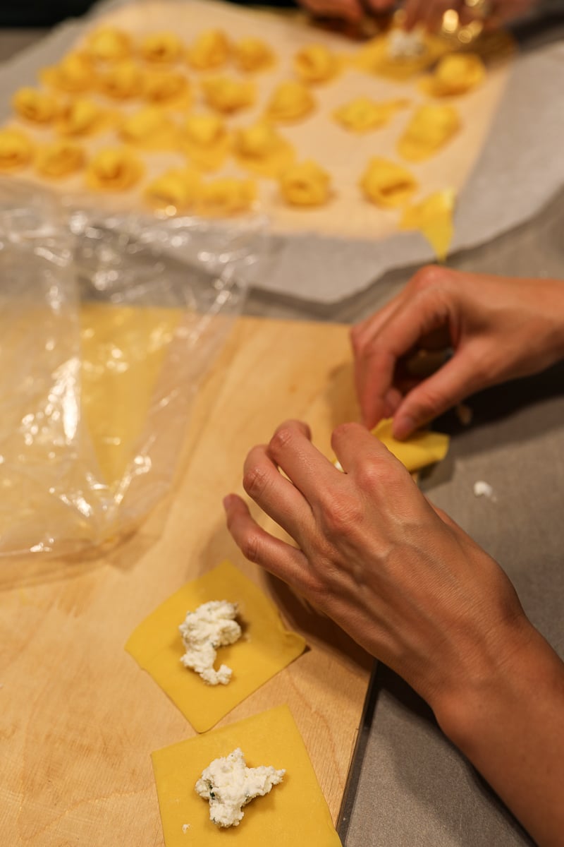 Maddy sealing a piece of tortelloni that has been stuffed with ricotta cheese.