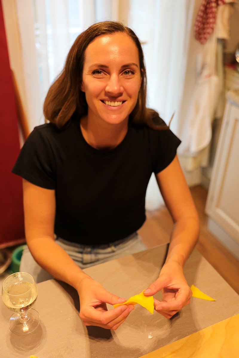 Maddy smiling while making tortelloni by hand during a cooking class in Italy.