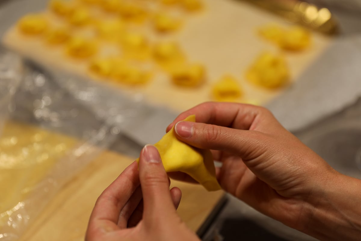 Maddy making tortelloni by hand during a cooking class - this is one of the best things to do in Bologna, Italy!