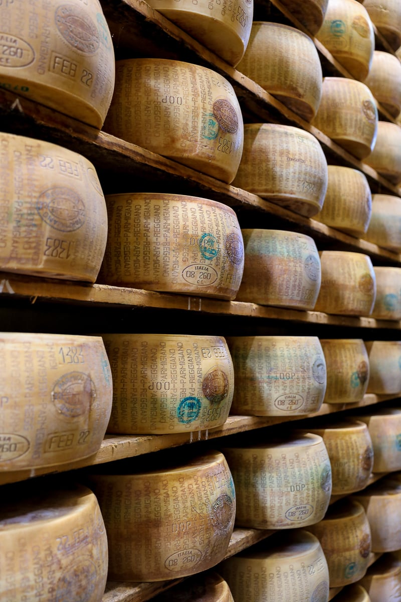 A factory shelf full of wheels of Parmigiano Reggiano during a food factory tour from Bologna