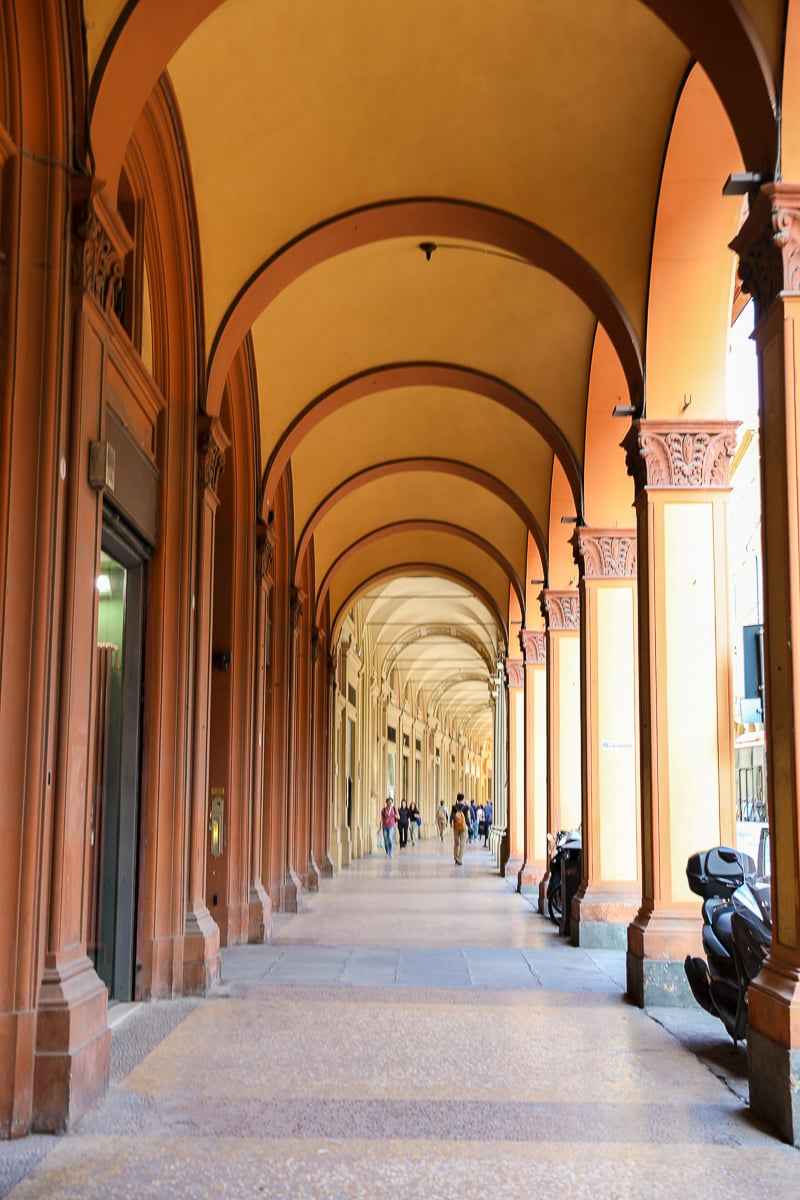 A portico walkway with arched ceilings. Walking along these porticoes is one of the best things to do in Bologna