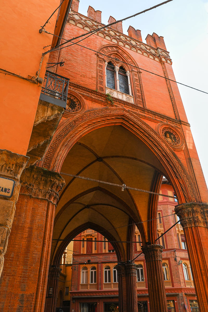 A beautiful red-brick building with a portico underneath in Bologna, Italy