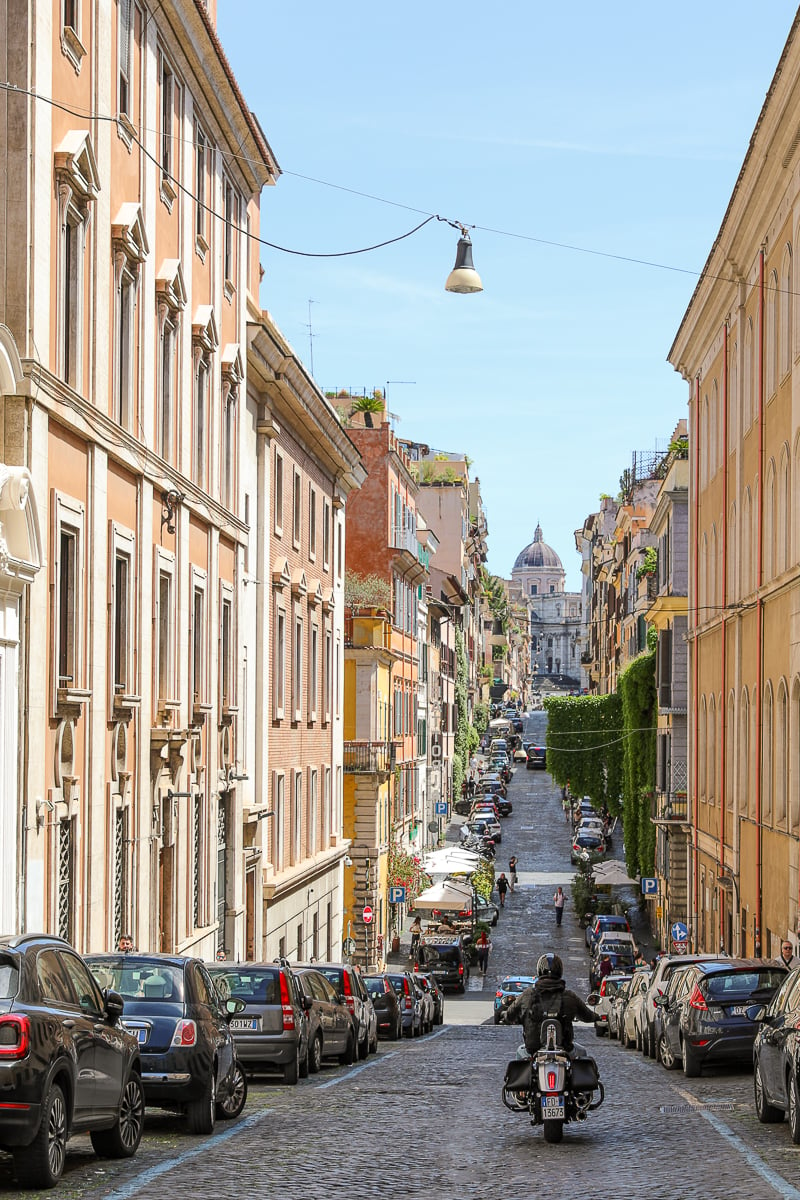 A gorgeous street in Rome with a cathedral in the background