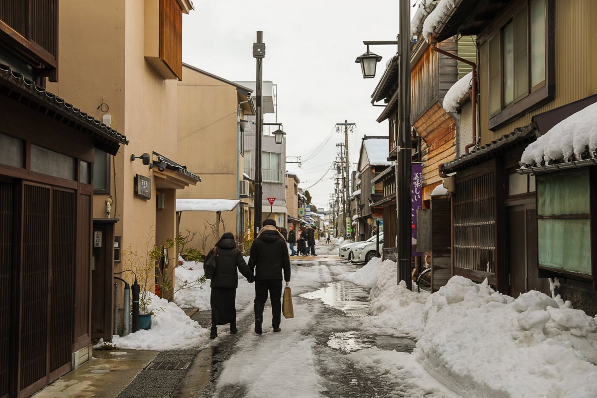Couple walking along the snowy streets of Kanazawa