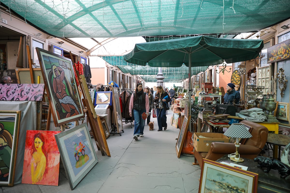 An outdoor flea market filled with paintings and antique furniture