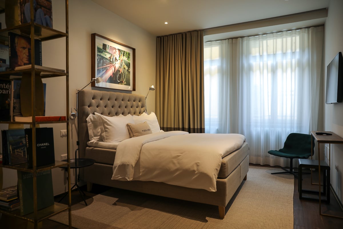 A stylish hotel room with a bed and a bookshelf in the Porta Nera Private Living hotel in Florence