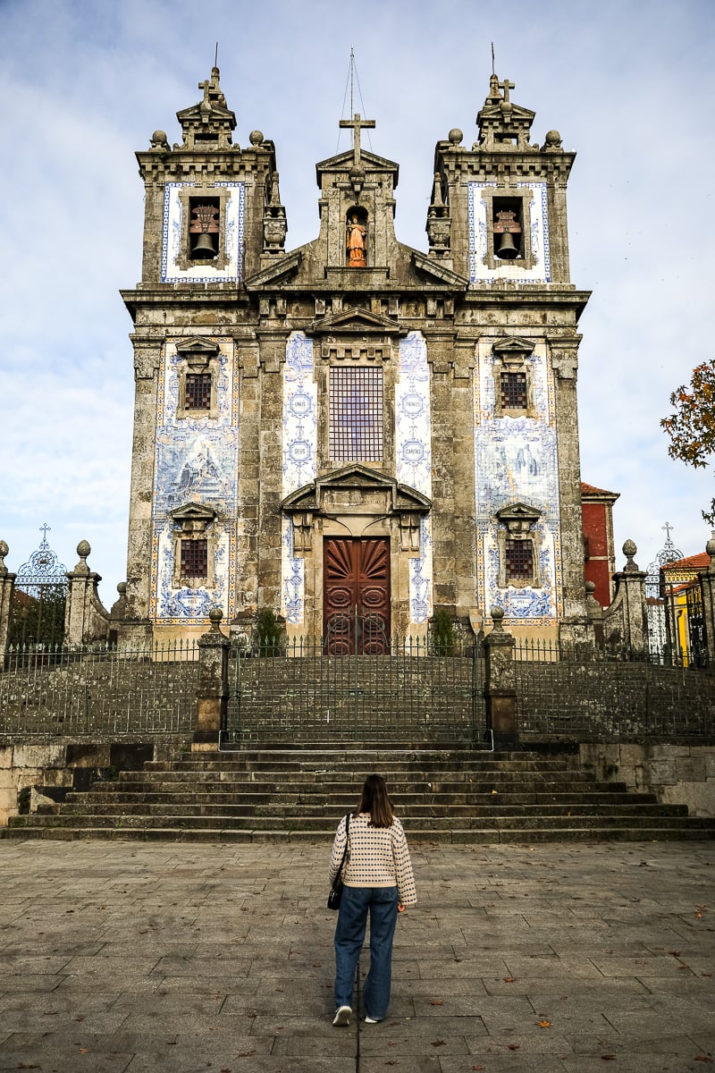Maddy standing in front of a beautiful baroque church in Porto. In this 3 days in Porto itinerary, you'll find some old churches to marvel at.