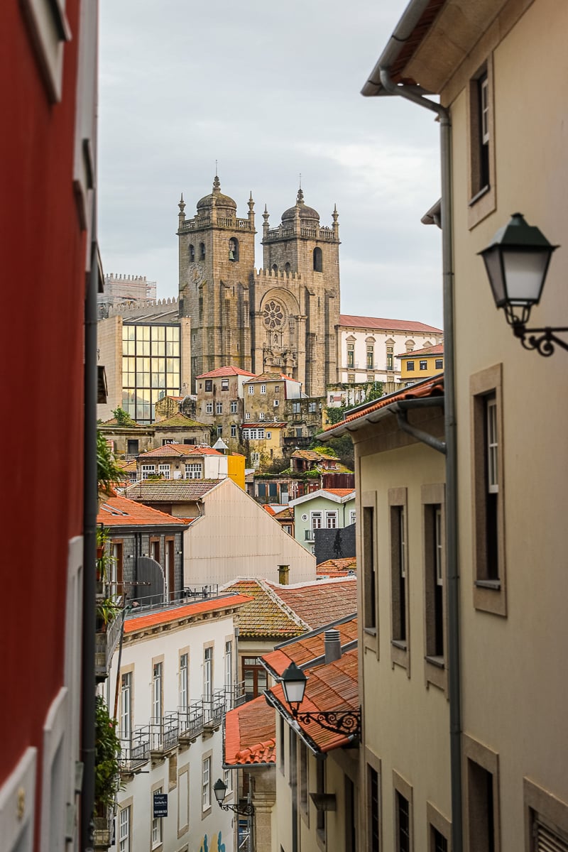 View of an old church towering above the city buildings as seen from a viewpoint. See the corners of this ancient city when you have 3 days in Porto.