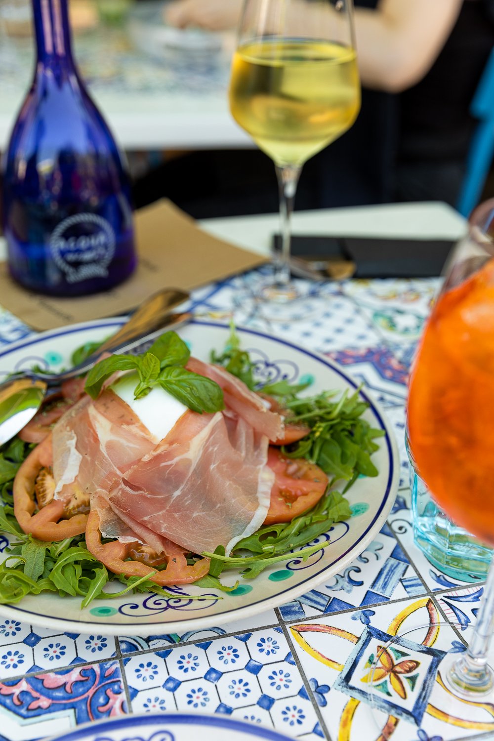 Fresh salad served on a plate with a glass of wine at a restaurant in Capri