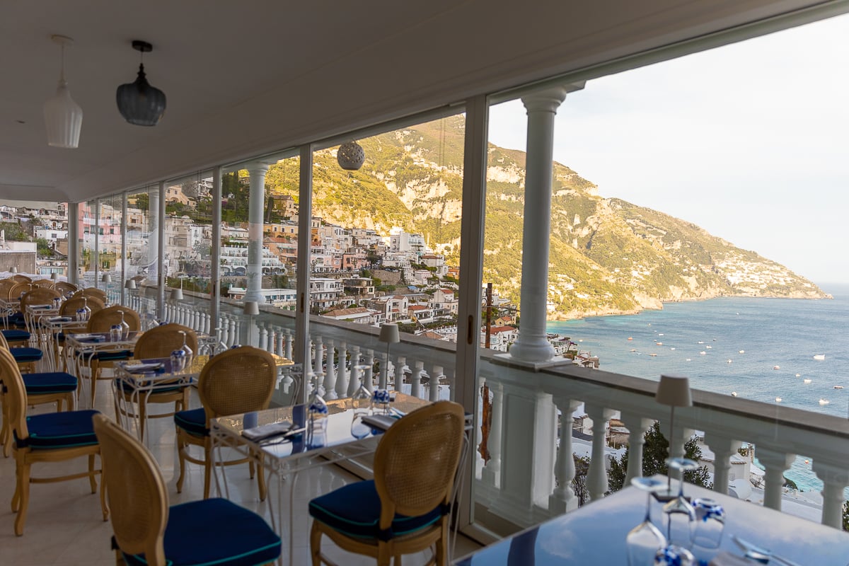 Dining area on a hotel terrace with a view of the village and the sea