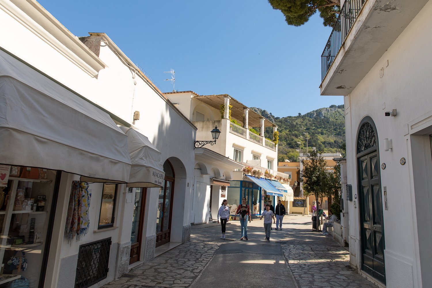 Tourists strolling the streets in Capri lined with shops and restaurants