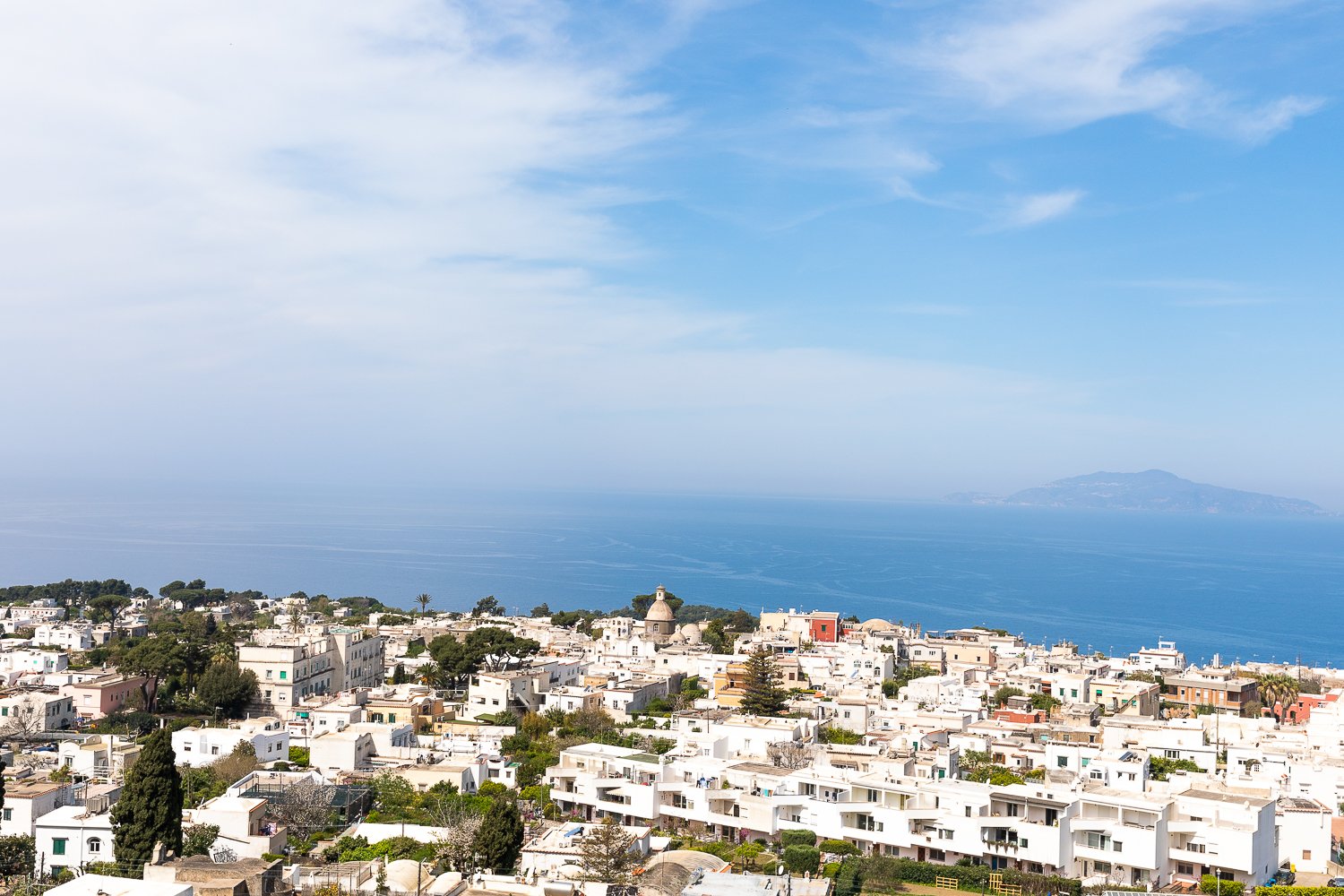 Capri's landscape with the view of its whitewashed buildings and the vast blue sea and sky