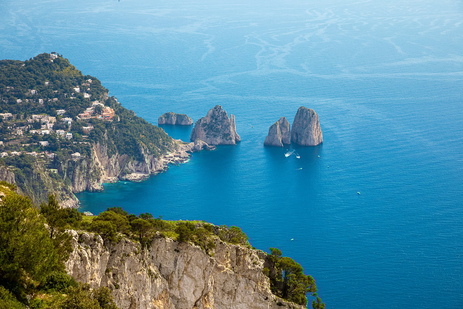 Rock formations standing in the blue ocean near the island of Capri