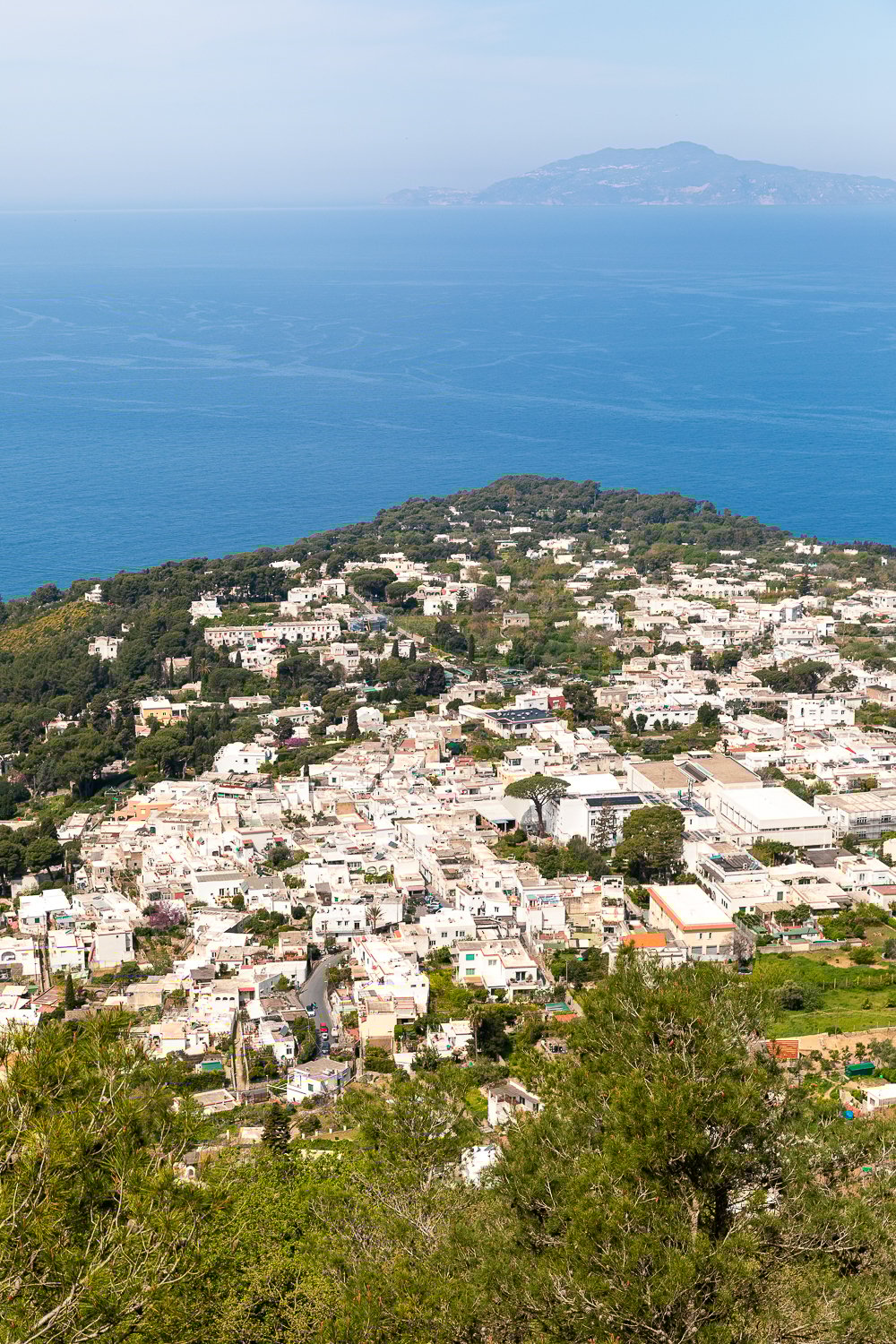 View of light-colored buildings in the island of Capri and the blue ocean on a sunny day