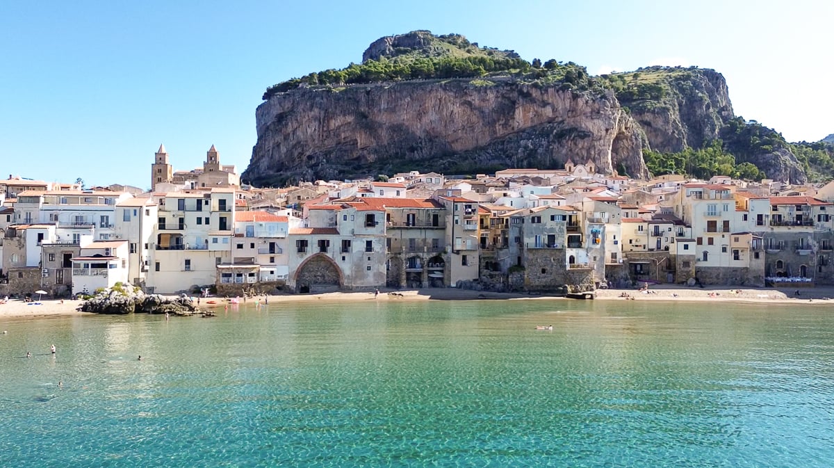 Medieval buildings of Cefalu along the emerald coast on a sunny day