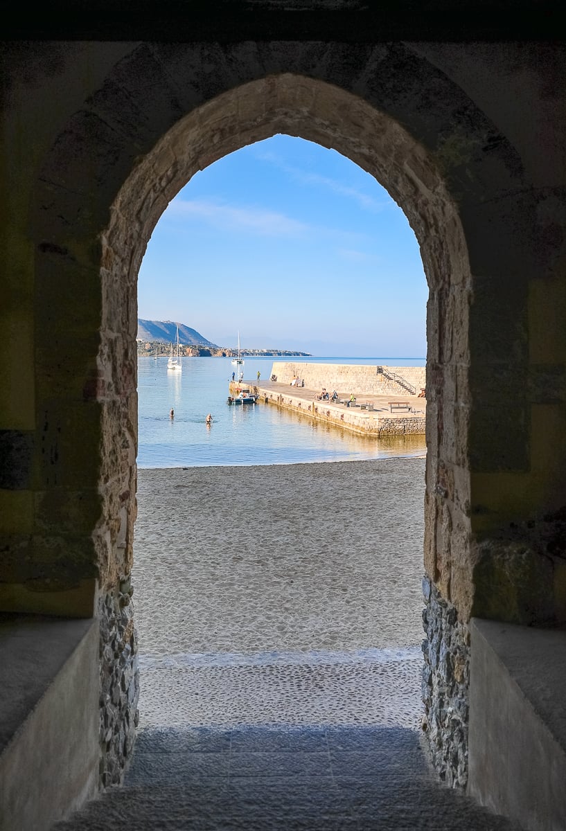View of the seaside as seen from a stone arched doorway