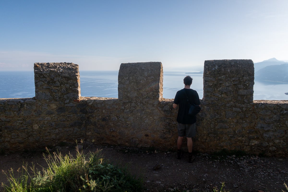 Cacey on a castle's rooftop ruins overlooking the blue sea and sky