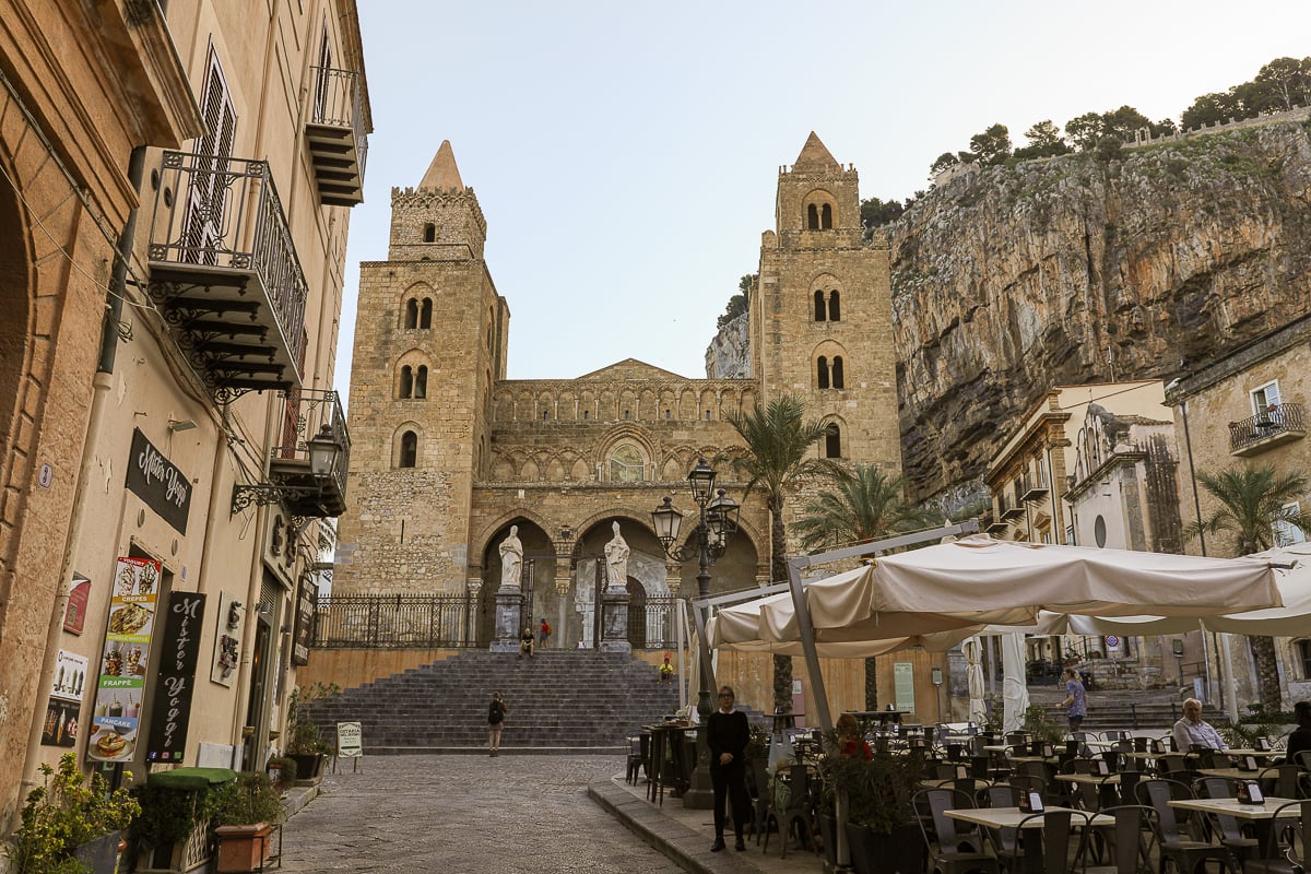 Cefalù cathedral with outdoor restaurant tables in the foreground
