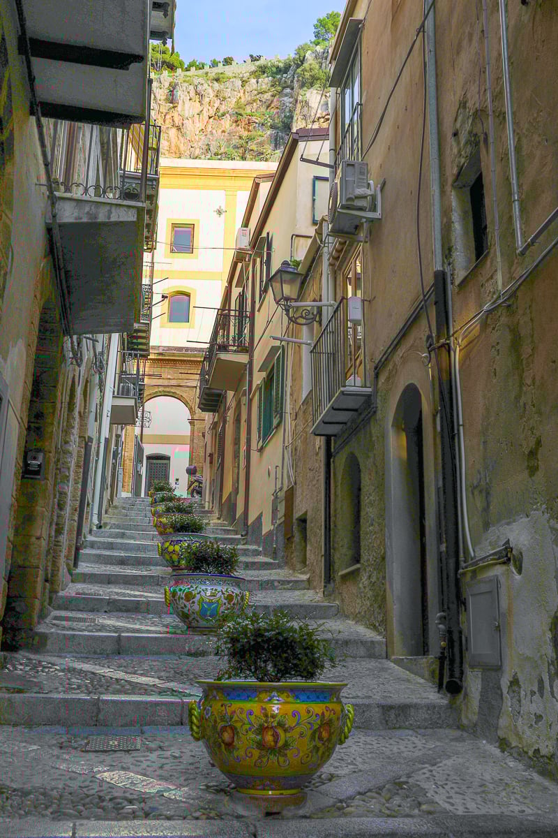 Colorful ceramic pots lining the middle of the stairs in a neighborhood in Cefalù