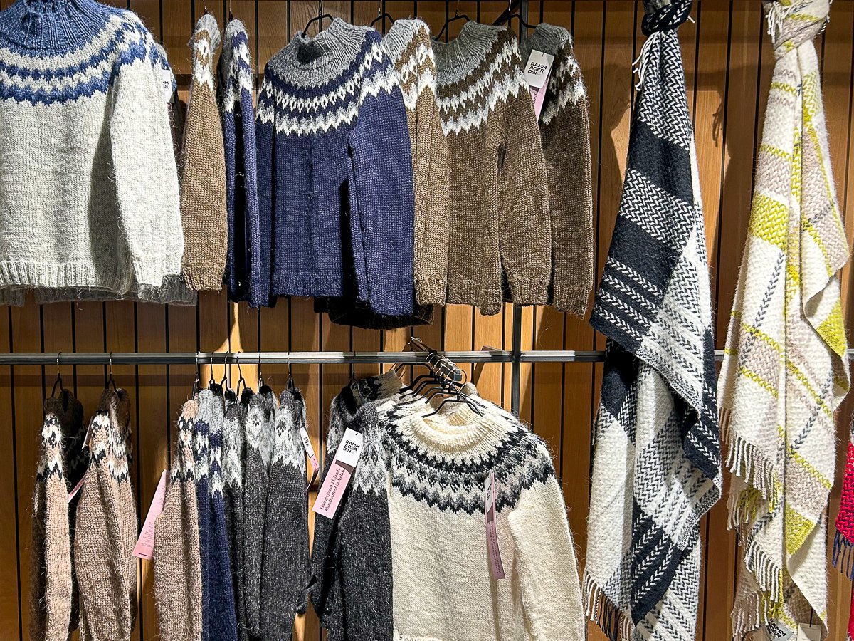 Handmade sweaters and blankets hanging from racks at a local shop in Reykjavík