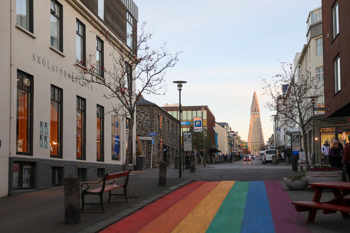 Rainbow-painted street in Reykjavík with a view of the Hallgrímskirkja from afar