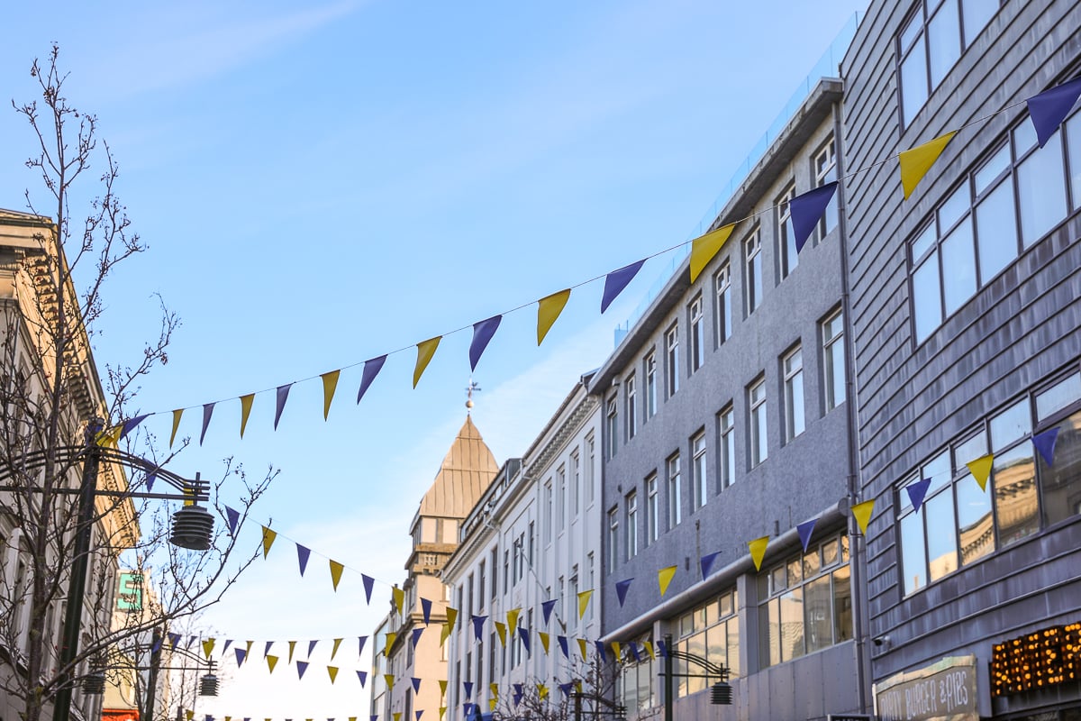 Colorful banners of blue and yellow across a street in Reykjavík