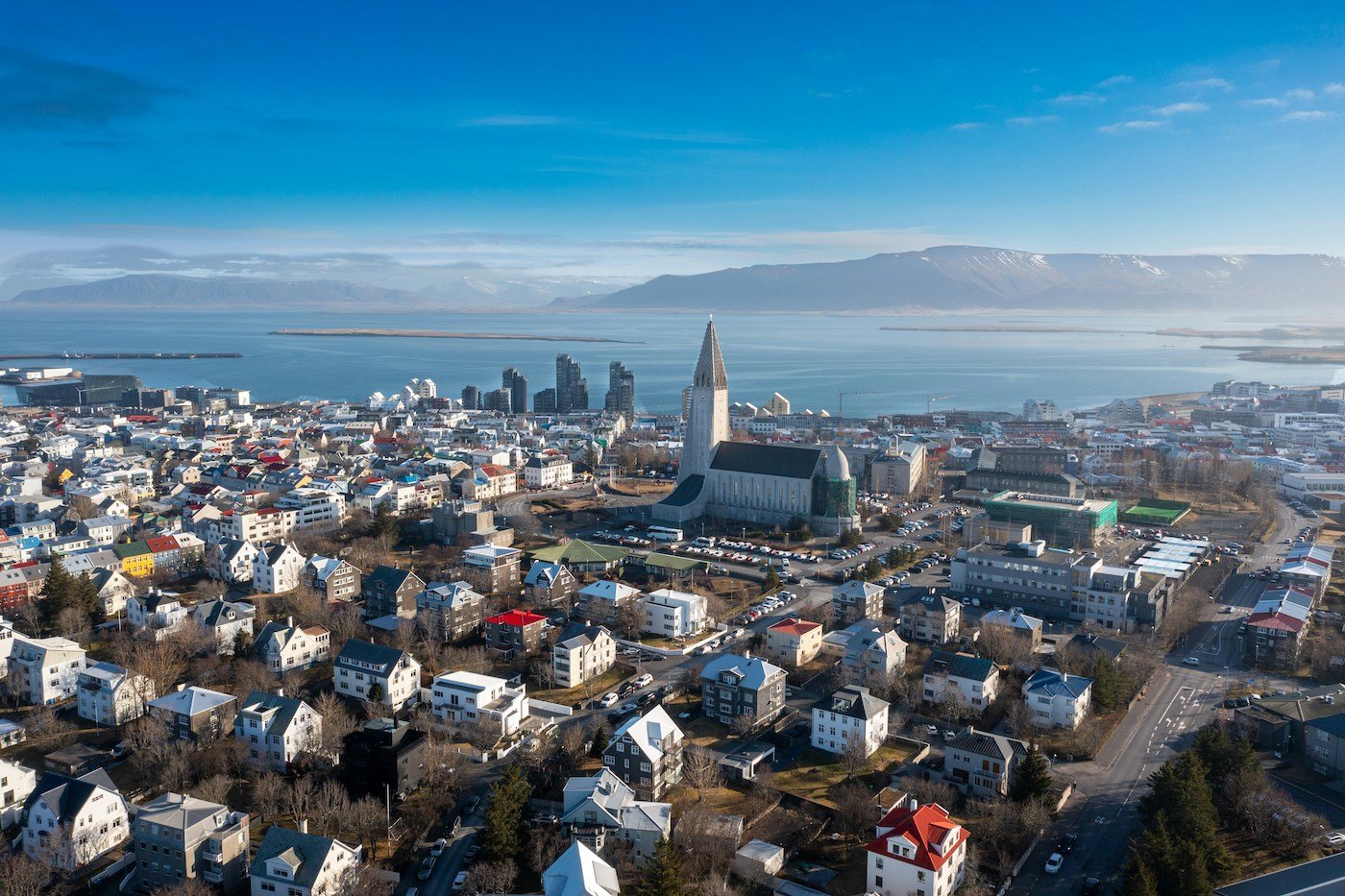 Panoramic view of Reykjavík featuring Hallgrímskirkja in the center and a view of the ocean and mountains from afar
