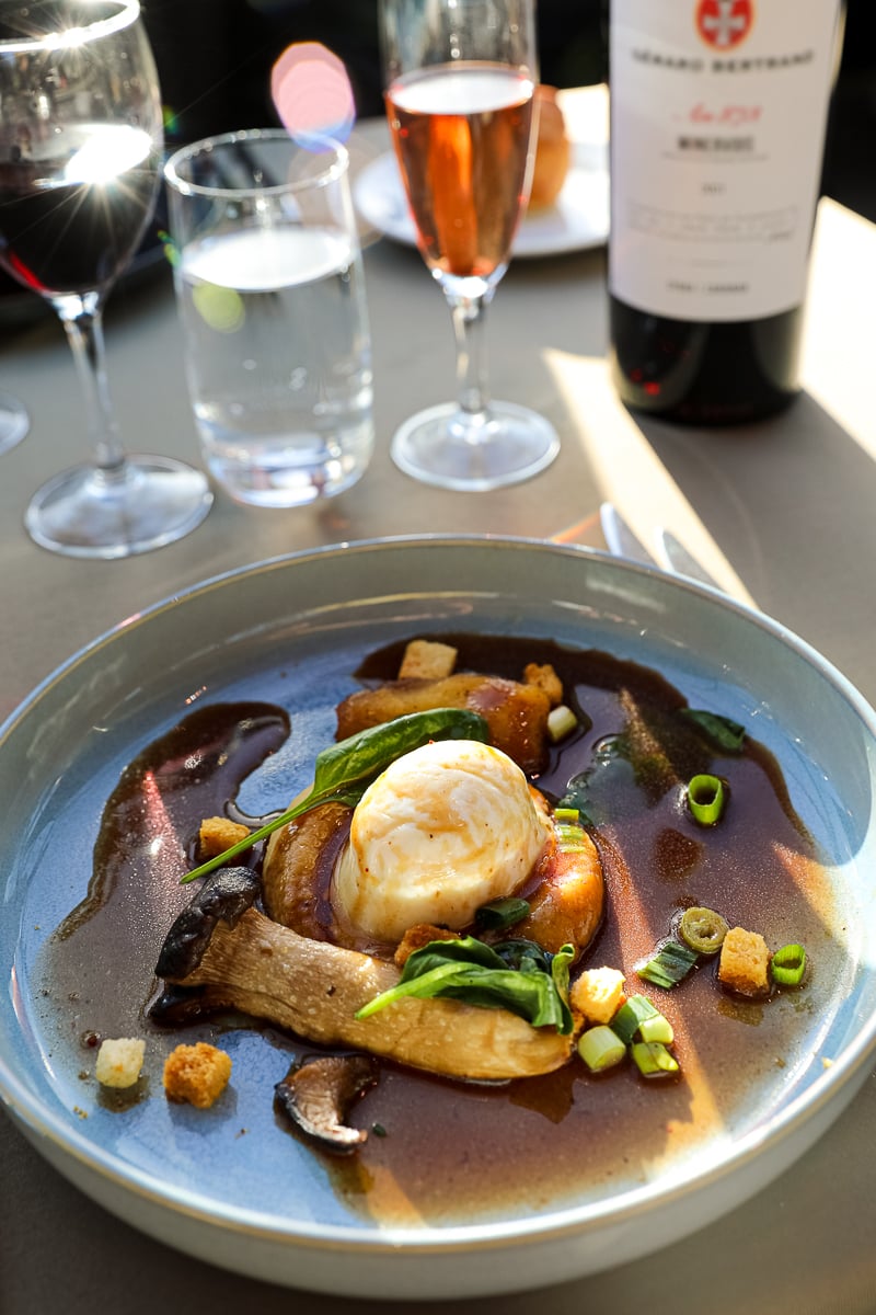 Poached egg starter with red wine sauce, king oyster mushrooms, and croutons aboard Paris lunch cruise