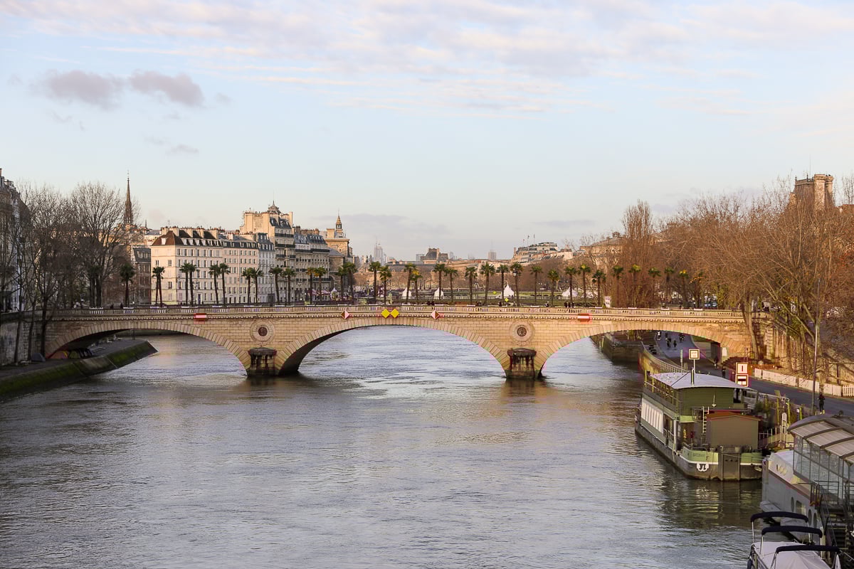View of a bridge and the Seine at golden hour in Paris.
