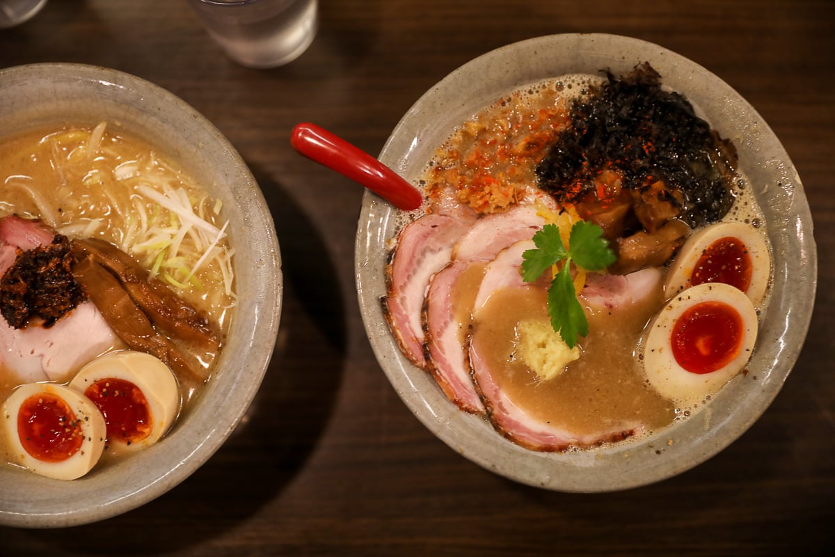 Rich bowls of crab miso ramen and pork chashu ramen topped with marinated eggs at a cozy Kanazawa ramen shop.