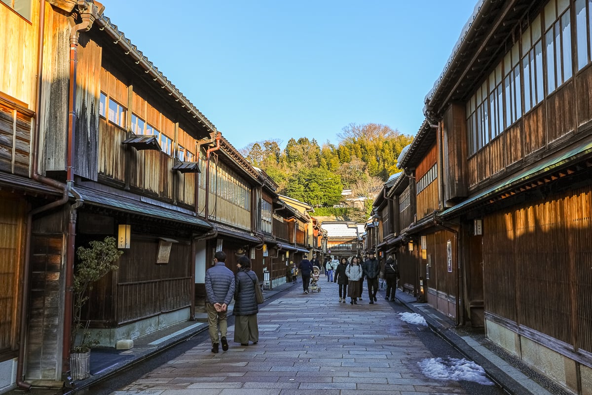 Charming wooden teahouses lining the main street of Kanazawa’s Higashi Chaya District, glowing in golden afternoon light.