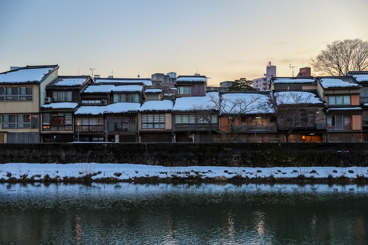 Traditional wooden buildings along the Asano River at sunset.