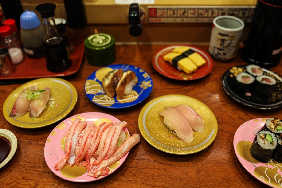 Colorful plates of sushi—crab, tuna, eel, and tamago—served at the popular conveyor-belt restaurant Mori Mori Sushi in Kanazawa, Japan.