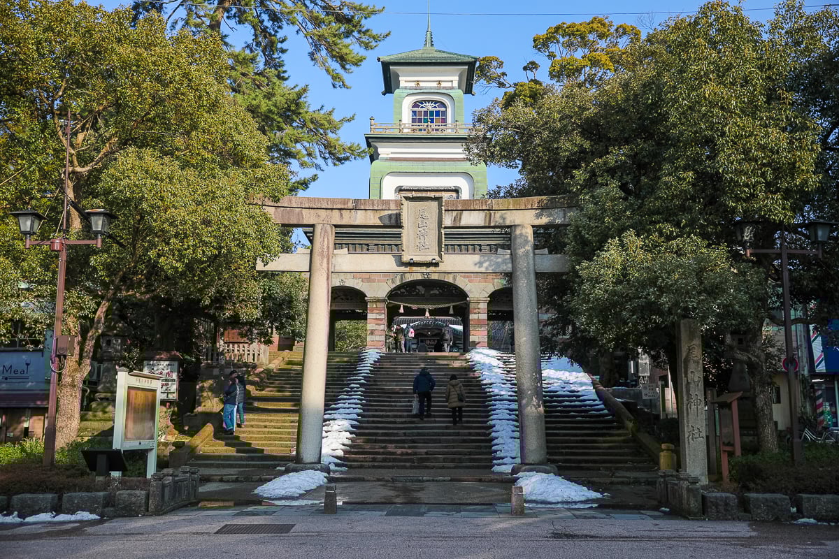 Entrance to Oyama Shrine with its distinctive Dutch-style gate, stone torii, and snow-dusted steps in Kanazawa, Japan.
