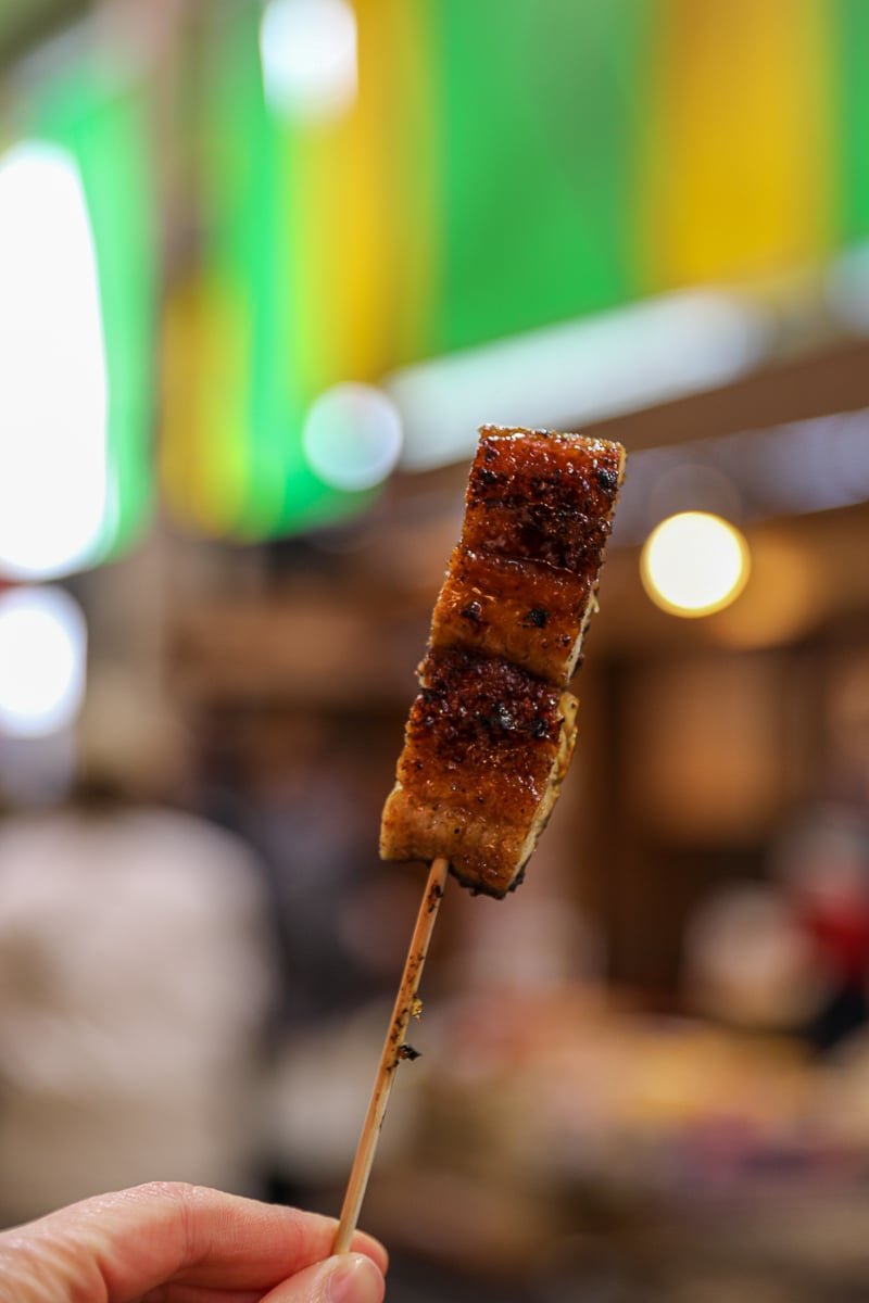 Grilled unagi eel skewer glazed with sweet soy sauce, a popular street-food snack at Omicho Market in Kanazawa, Japan.