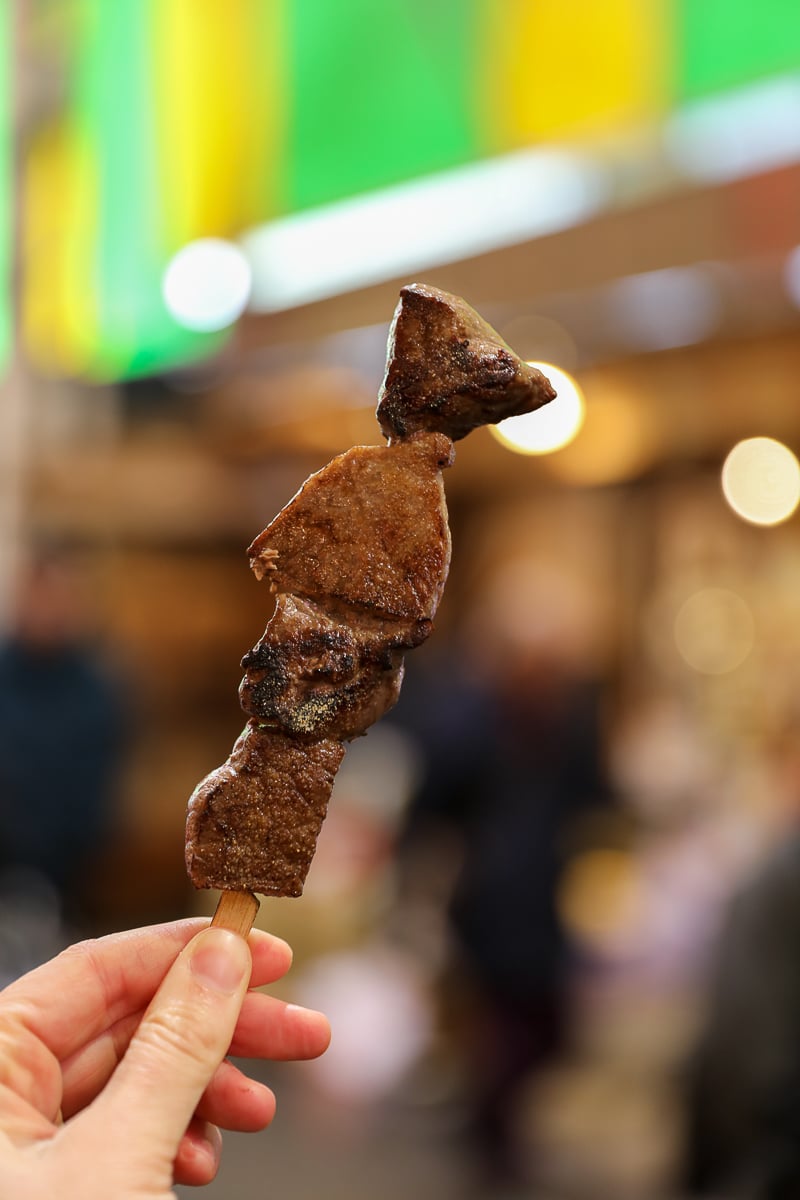 Grilled wagyu beef skewer sprinkled with edible gold, a street-food favorite at Omicho Market in Kanazawa, Japan.