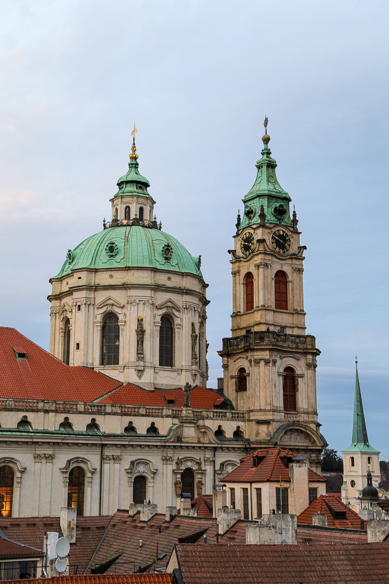 Baroque church domes and towers rising above Prague rooftops, a defining skyline feature of Malá Strana and central Prague neighborhoods.