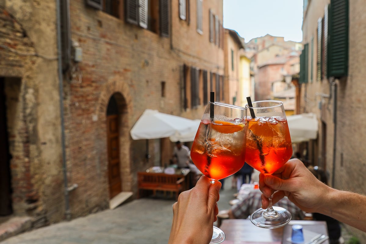 Classic aperitivo drinks in a narrow historic street in Siena